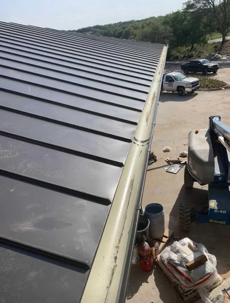Standing seam panel and gutter detail on a metal roofing jobsite in Macon-Bibb County